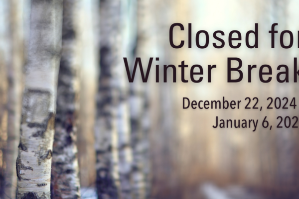 Blurred image of birch trees with text announcing that we are closed for winter break from December 22, 2024, to January 6, 2025.