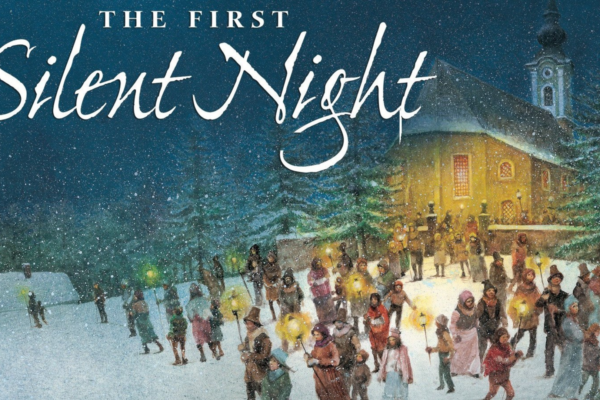 Illustrated scene of a snowy evening with a crowd of people holding glowing candles and walking towards a warmly lit church. The words "The First Silent Night" are written in script at the top of the image. Snow-covered trees and buildings are in the background.