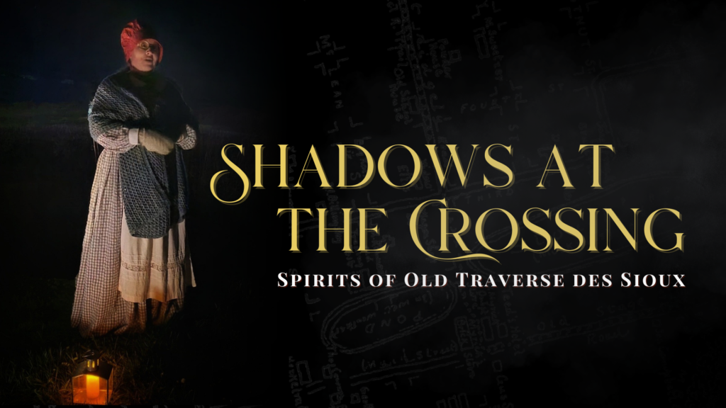 A person dressed in historical attire stands in the dark holding a lantern, beside text that reads, "Shadows at the Crossing: Spirits of Old Traverse des Sioux." A faint map is visible in the background.